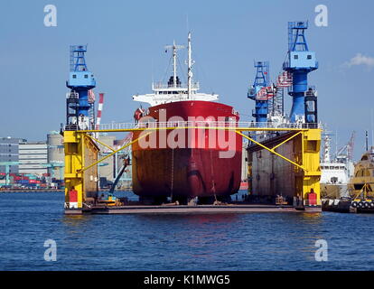 KAOHSIUNG, TAIWAN -- AUGUST 13 , 2017: A large ship is being assembled in a dry dock by a commercial shipyard operation. Stock Photo
