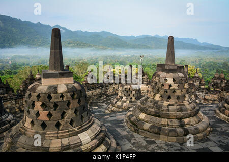 Stone stupas of Borobudur Temple on Java, Indonesia. Built in the 9th century, the temple was designed in Javanese Buddhist architecture. Stock Photo