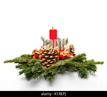 Christmas centerpiece decoration with a red color candle and fir tree leaves. Stock Photo