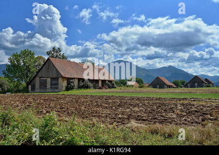 Traditional barns in Turiec region, country Slovakia, Europe. In the foreground of the field and in the background of a high mountain. Stock Photo