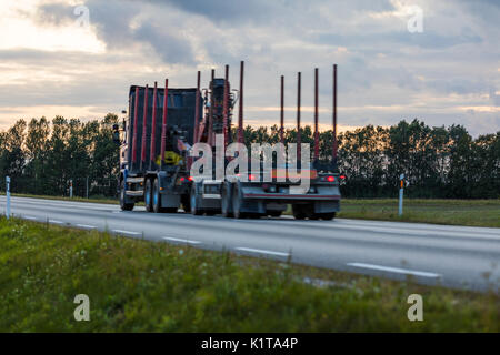 Speeding motion blur oncoming trucks with glowing lights on the highway after sunset. Abstract blur image background with copy space. Stock Photo