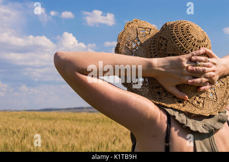 Caucasian woman  with hands behind head, staring at horizon on a summer day. Stock Photo