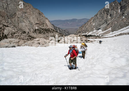 Backpackers hike up a snowfield on the way up the Mt. Whitney trail during June 2017. Stock Photo
