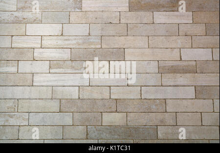 Wall of white and gray adarce travertine stone brick blocks, close up background texture, side view Stock Photo