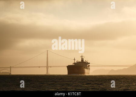 Giant tanker ship and golden gate bridge at sunset Stock Photo