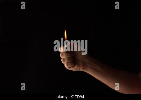 hand holding a lighter in a dark Stock Photo