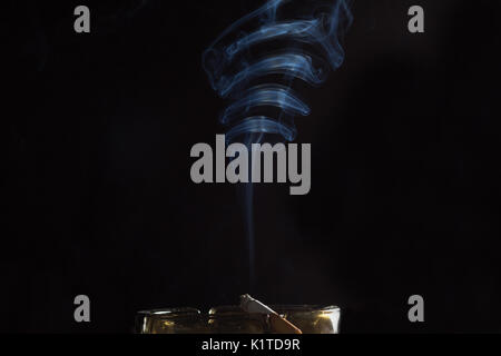 smoke from a cigarette on an ashtray Stock Photo