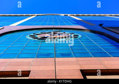 Commercial and business building facade with clock and blue sky in the background Stock Photo