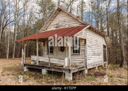 Old abandoned wood cabin with a covered front porch, on piers, in rural Alabama, USA. Stock Photo