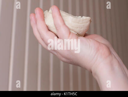 Hand holding a single raw biscuit in the air Stock Photo
