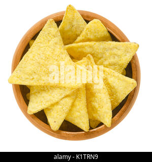 Tortilla chips in wooden bowl. Snack food made from corn tortillas or corn masa, cut into triangle shaped wedges, fried in oil and salted. Stock Photo