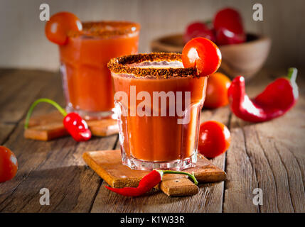 Spicy bloody with smoked chili pepper on wooden background Stock Photo