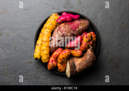Peruvian raw ingredients for cooking - yuca, colored sweet potatoes and camote batata. Top view. Stock Photo
