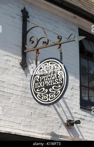 A Pizza Express sign hanging on a wall outside a restaurant in Arundel, West Sussex, England. Stock Photo
