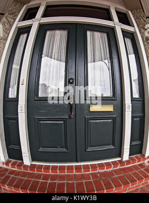 New Orleans, LA USA - June 1, 2017  -  Dark Green Door with Windows in the French Quarter Stock Photo