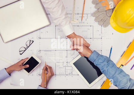 Hands of professional architects discussing and working with blueprints Stock Photo