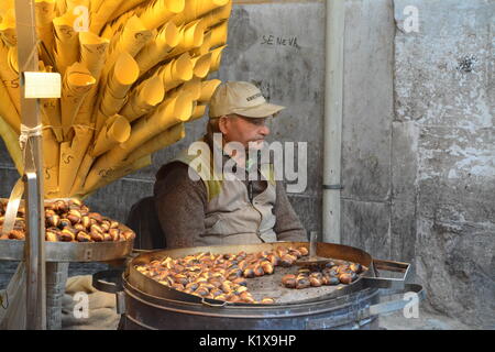 Elderley man selling roasted chestnuts in Rome, Italy Stock Photo