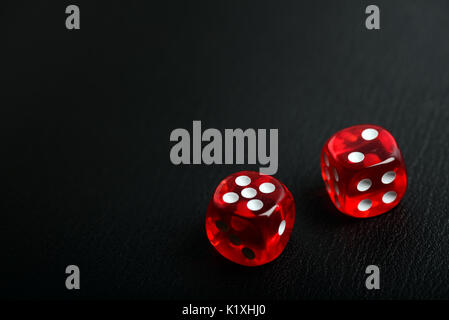 Two red casino poker dice counting seven on a bleack leather background with copy spce for your text Stock Photo