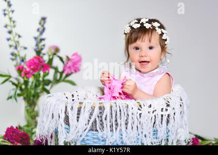 beautiful little child sits with a flower. Stock Photo