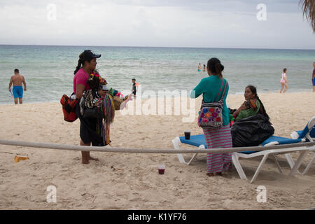 Group of local sales women  in Mayan Riviera on the beach with bags of colorful crafts to sell. Stock Photo