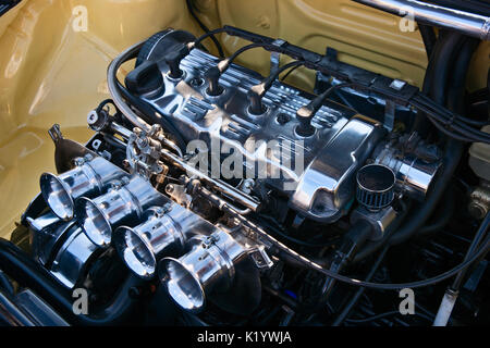 Modern automobile internal-combustion engine. White polished metal and black tubes and wires. Automotive industry scene. Stock Photo