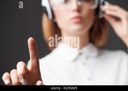 Young businesswoman pressing high tech type of modern buttons. Stock Photo