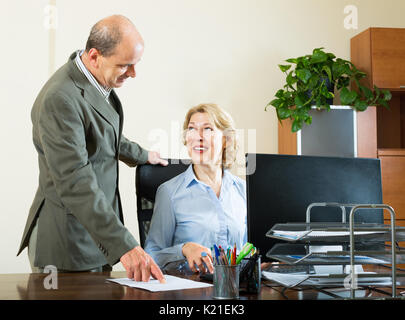 Two elderly colleagues discussing business issues in the office Stock Photo