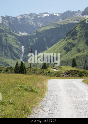 Scenic Alpine rocky alpine valley of Sportgastein in summer with row of power lines and electricity pole. Picturesque mountain pasturelands. Stock Photo