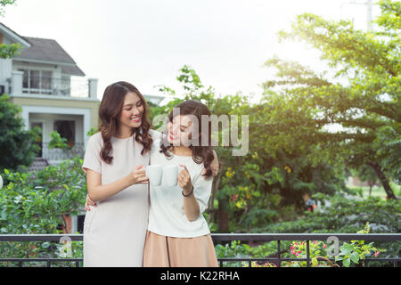 Happy young women friends well-dressed smiling while standing together Stock Photo