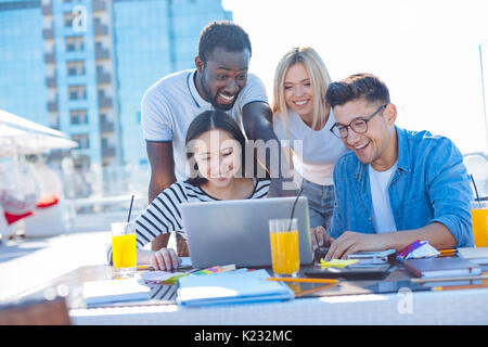 Adorable students smiling while working on project together Stock Photo