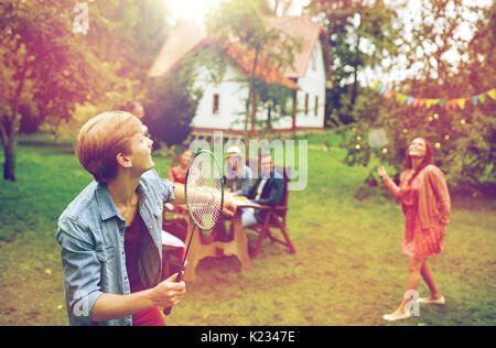 happy friends playing badminton at summer garden Stock Photo