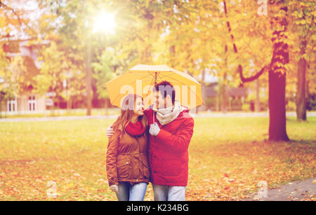 smiling couple with umbrella in autumn park Stock Photo