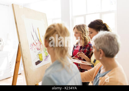 women with easel and palettes at art school Stock Photo