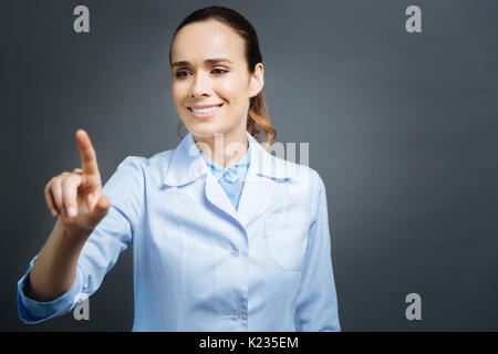 Beautiful medical professional using invisible touchscreen Stock Photo