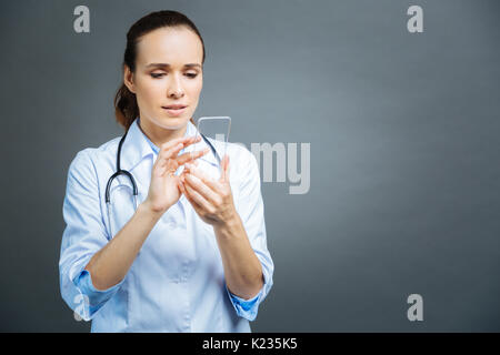 Beautiful physician using transparent phone Stock Photo