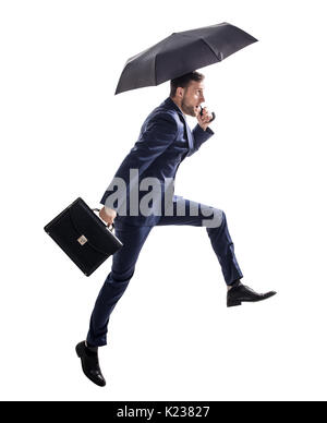 Businessman running with umbrella and briefcase. Stock Photo