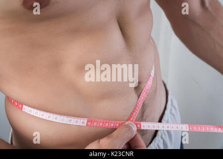 Image of muscular man measure his waist with measuring tape in centimeters  Stock Photo - Alamy