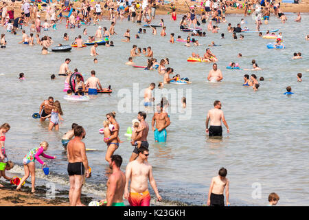 Many people paddling in the sea during heatwave in the summer. Broadstairs resort, Viking bay beach. Stock Photo