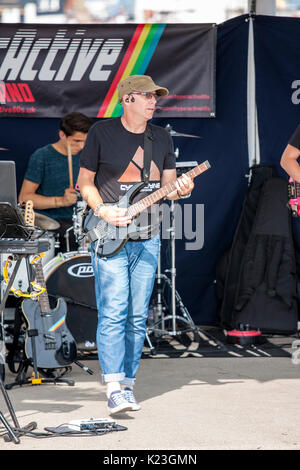 England, Broadstairs bandstand. 80's tribute group, 'Hyper Activer' playing in the summer sunshine. Lead bass guitarist, Steve Rickwood on stage performing. Stock Photo