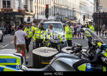 London, UK. 28th August, 2017. Unusual security measures are taken by Metropolitan Police to safeguard the main parade of Notting Hill Carnival. Big number of officers and security barriers are taking care of publics safety. Carnival as usual attracted thousands of people. Credit: Dominika Zarzycka/Alamy Live News Stock Photo