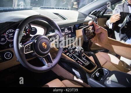 Stuttgart, Germany. 29th Aug, 2017. A visitor of the premiere photographs the interior of the car model during the introduction of the new 'Cayenne' Generation at the Porsche Museum in Stuttgart, Germany, 29 August 2017. The 3 litre variation of the Cayenne Generation is part of the 'waste gas scandal' - it remains unknown whether the newes generations will be produced with a diesel motor at all. Photo: Sebastian Gollnow/dpa/Alamy Live News Stock Photo