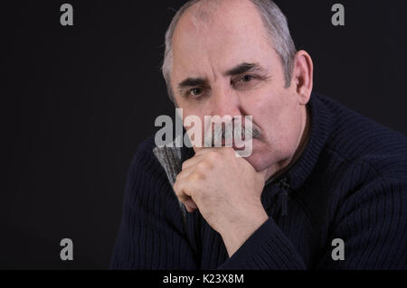 Nice portrait of mature Caucasian man thinking in darkness Stock Photo