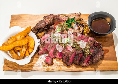 Grain fed Grilled Tomahawk Beef steak with fried potato wedge Stock Photo
