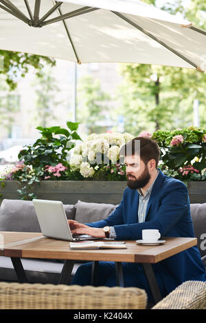 Modern Businessman Working with Laptop Outdoors Stock Photo
