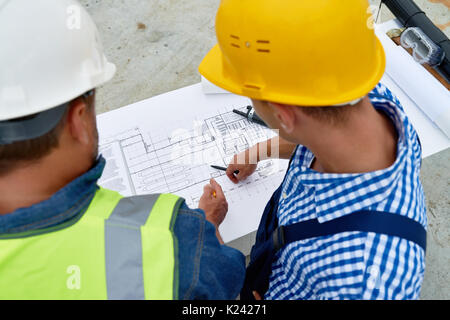 Builders Checking Floor Plans on Site Stock Photo