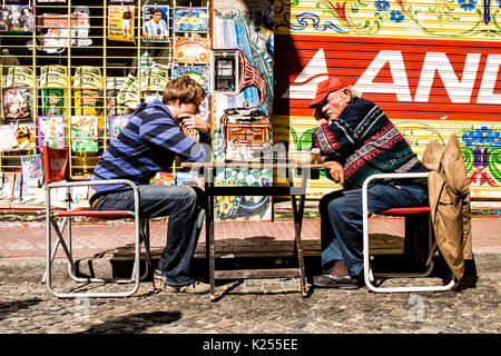 Young and elder man playing chess on the street in San Telmo neighborhood. Buenos Aires, Argentina. Stock Photo