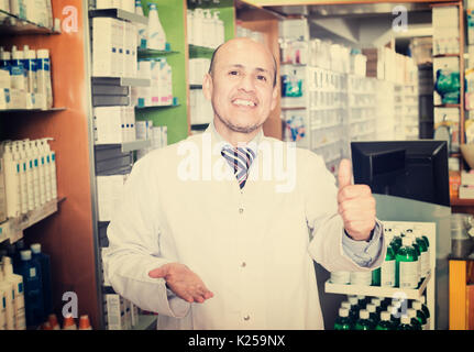 Portrait of male pharmacist working in modern farmacy and smiling Stock Photo