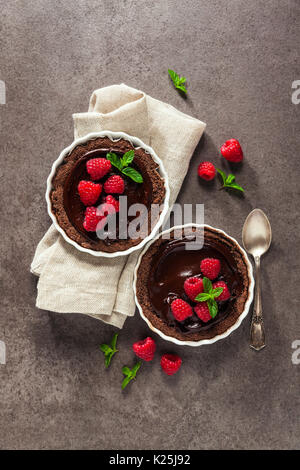 Chocolate raspberry tarts mint leaves on dark stone background Stock Photo