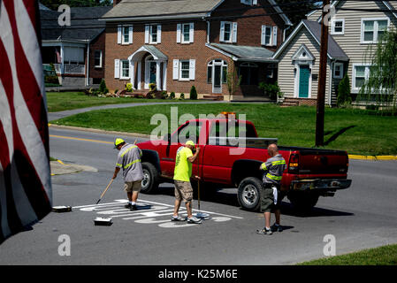 Crew painting school sign on asphalt preparing for the new school year. Stock Photo