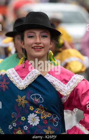 June 17, 2017 Pujili, Ecuador: young indigenous woman in bright color traditional clothing at Corpus Christi parade dancing in the street Stock Photo